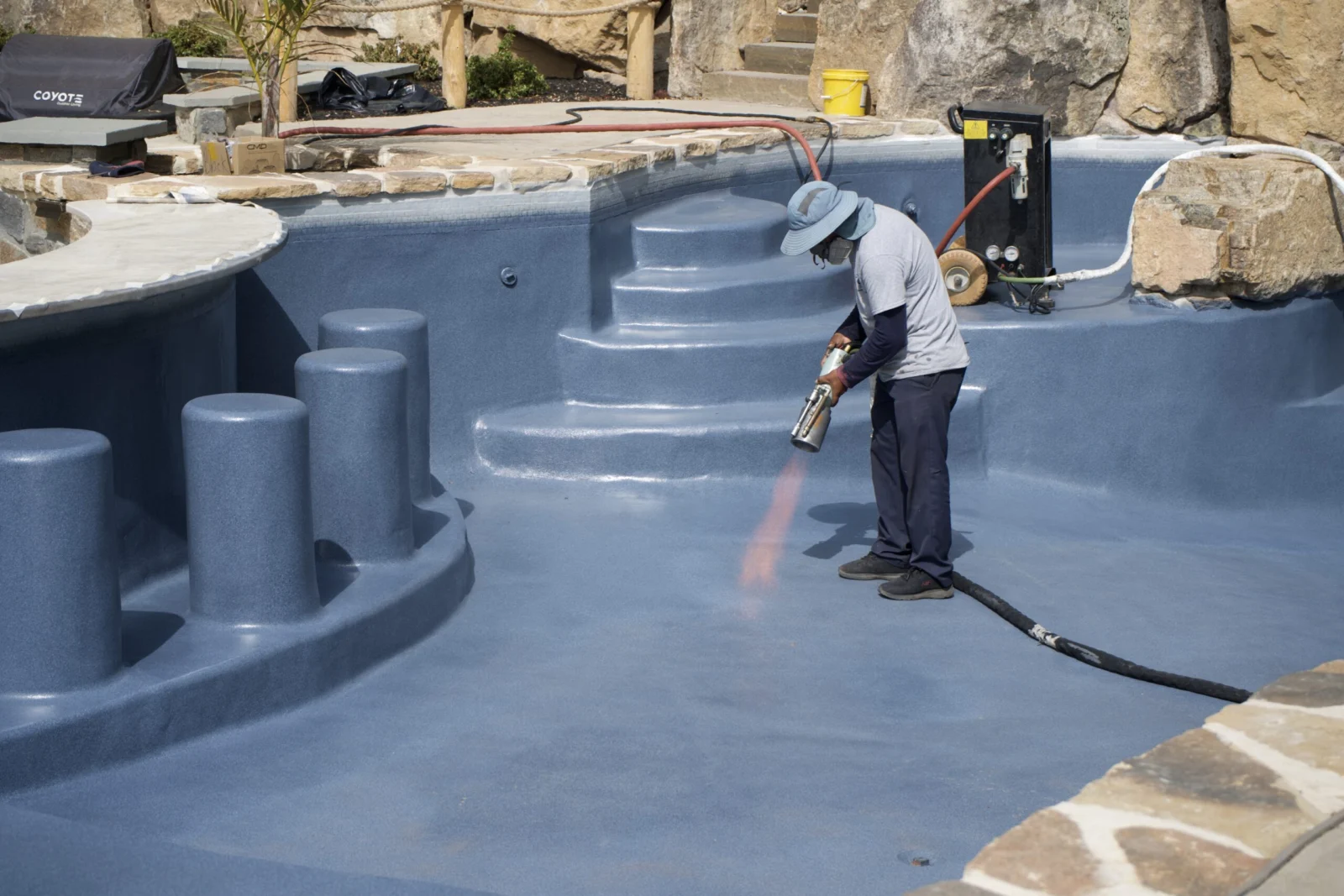ecoFINISH applicator flame-spraying aquaBRIGHT onto a pool interior